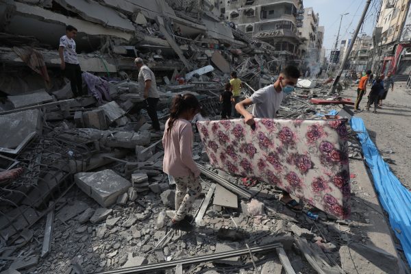 Palestinians inspect the ruins of Aklouk Tower destroyed in Israeli airstrikes in Gaza City